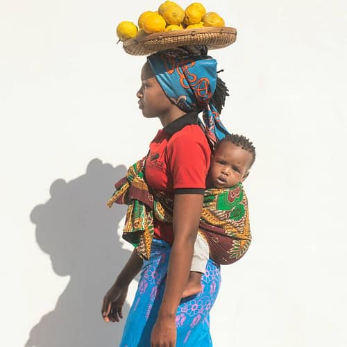 Afrikaanse vrouw met haar baby op haar rug in een draagdoek