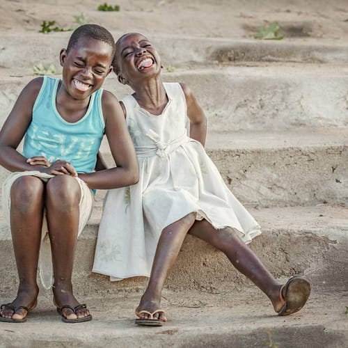 Twee Afrikaanse kinderen hebben dikke pret terwijl ze op de foto worden gezet