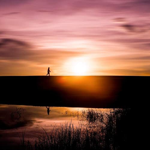 Wandelaar tijdens een kleurrijke zonsondergang